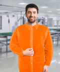 Individual wearing an Orange Disposable Lab Jacket for adults, showcasing snap front and collar in a medical setting.