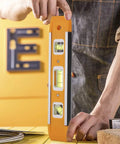 Person using Nine Inch Magnetic Torpedo Level With Three Bubble Vials For Horizontal Vertical And 45 Degree Readings Shock Resistant ABS Frame Heavy Duty Magnetic Base Bright Orange On Site Construction And Woodworking Tool For Precise Layouts