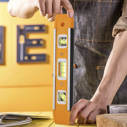 Person using Nine Inch Magnetic Torpedo Level With Three Bubble Vials For Horizontal Vertical And 45 Degree Readings Shock Resistant ABS Frame Heavy Duty Magnetic Base Bright Orange On Site Construction And Woodworking Tool For Precise Layouts
