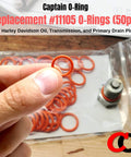 Person holding an orange O-Ring #11105 from a 50 pack for oil drain plugs, suitable for engine crankcase, transmission, and primary drains.