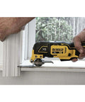 Person using 20V Max XR Oscillating Tool Kit With Blades And Charger Included on window trim