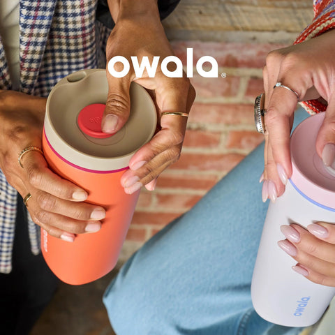Two people holding insulated stainless steel tumblers with leak-proof SmoothSip slider lids in an outdoor setting.