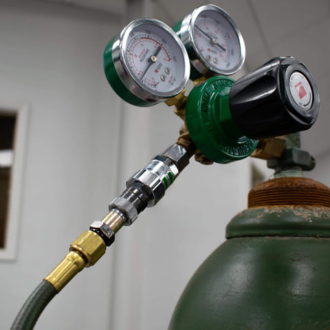 Side view of an Oxy-Fuel Quick Connect Regulator To Hose Coupler Set For Fuel And Oxygen on a gas cylinder