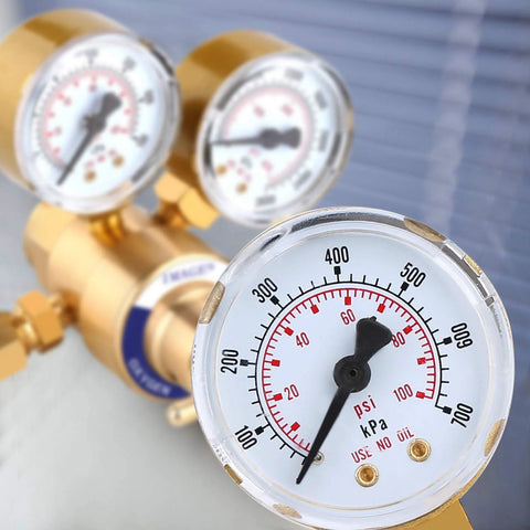 Close-up of oxygen welding regulator CGA 540 with 2-inch gauges displaying psi and kPa for oxy-fuel cutting.