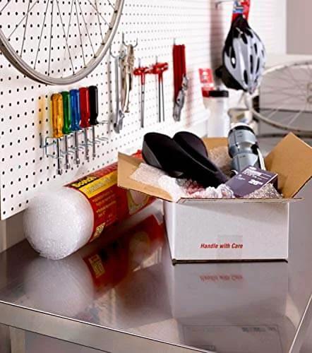 Scotch Sure Start Packing Tape Clear 1.88 In X 22.2 Yd 6 Dispenser Rolls Quiet Unwind Easy Start Strong Hold on a metal workbench with packing supplies.