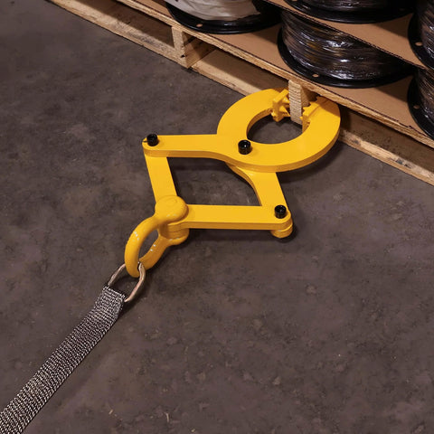 Beefy Heavy Duty Pallet Puller Clamp With 6000 Lb Capacity attached to pallet with strap on warehouse floor