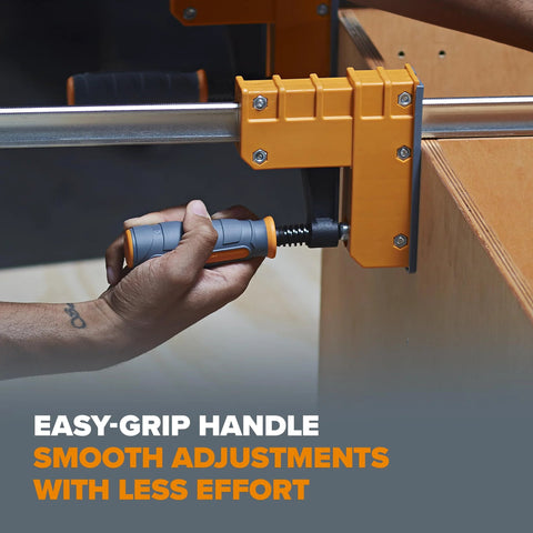 Close-up of person adjusting heavy duty 8 piece parallel clamp set for woodworking with easy-grip handle on wooden surface.