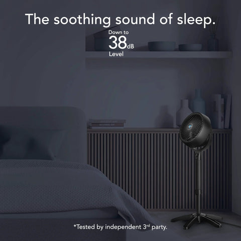 All Day Chill Pedestal Fan With Three Speed Control And Height Adjustable From 32 To 38 Inches Delivers Whole Room Air Circulation And Quiet Operation For Bedroom And Home By Vornado placed in a bedroom setting.