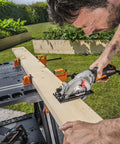 Man using Pegasus 2 In 1 Folding Work Table And Sawhorse Portable Workbench With Clamps WX051 to cut wood plank outdoors