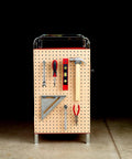 Pegboard tool organizer with assorted tools including pliers, hammer, and screwdriver displayed in a garage setting.