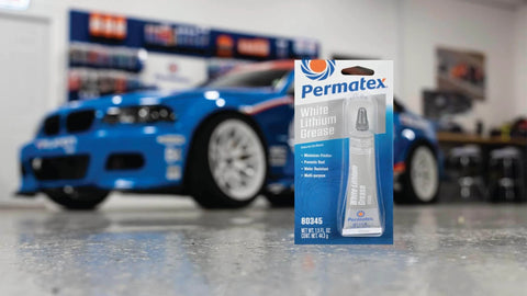 Permatex 80345 White Lithium Grease, 1.5 oz in packaging with blue car in background