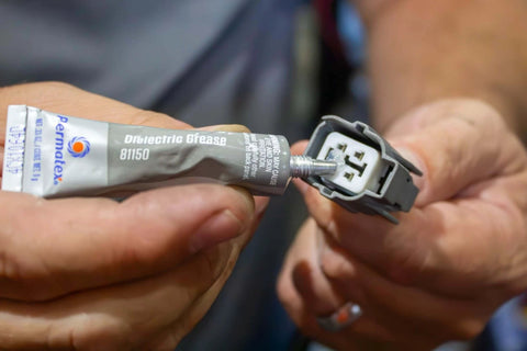 Applying Permatex 81150 Dielectric Tune-Up Grease, 0.33 oz. Tube, Silver to electrical connector for protection