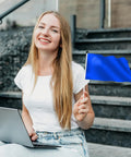 Woman sitting on steps holding a blue flag and using a laptop