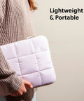Person holding a petal pink nylon puffy laptop sleeve, medium size, compatible with up to 14 inch laptops, lightweight and portable.