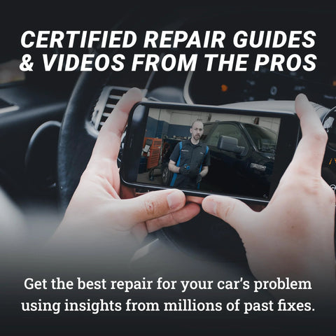 Person viewing car repair video on smartphone inside vehicle.