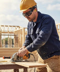Construction worker using saw wearing Photochromic Safety Glasses With Wraparound Lenses And Removable Foam Gasket