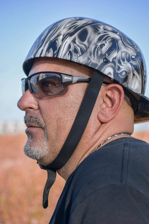 Man wearing Hercules 7 Photochromic Safety Sunglasses With Auto Darkening Lenses ANSI Z87.1 and a skull patterned helmet outdoors