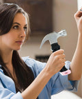 Woman using Pink 8 Oz Claw Hammer For Picture Hanging And Drywall Anchors With Shock Absorbing Non Slip Handle Lightweight Compact Design Ideal For Kids And Women Magnetic Nail Starter High Carbon Steel For Quick Diy Wall Fixes