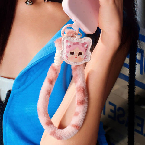 Crybaby Wild But Cutie Series Phone Charm Blind Box Wrist Strap Keychain for Phones in pink, shown attaching to a phone.