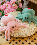 Super Soft Pink Spider Plush Toy For Kids And Adults Huggable Stuffed Animal 9.8 Inch Plush Pillow next to green spider
