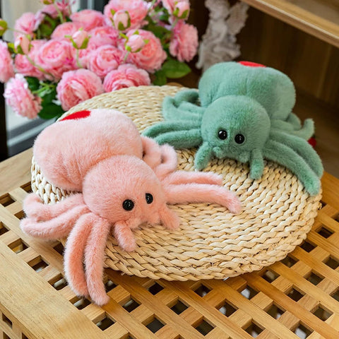 Super Soft Pink Spider Plush Toy For Kids And Adults Huggable Stuffed Animal 9.8 Inch Plush Pillow next to green spider