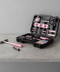 Open pink 142-piece household tool kit with storage case, showing tools for home repairs and DIY projects on a grey surface.