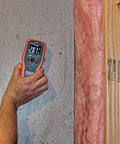 Person using Pinless Moisture Meter for Non-Destructive Moisture Detection in Drywall, Wood, and Masonry; Detects up to 3/4-Inch Below Surface on wall.