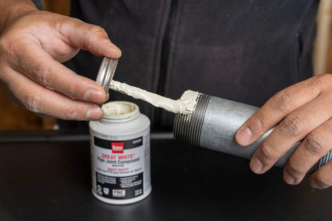 Applying Pro Grade Pipe Joint Compound With PTFE And Brush For Sealing And Lubricating Threaded Joints White Non Hardening Non Toxic Paste