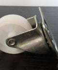 Alt Tag: Side view of a metal bracket with a plastic caster wheel, 100-Pack Plastic 2 Inch Caster Wheel - 360 degree Ball Bearing Rotating.