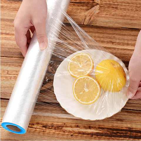 Hands using stretch film to cover lemon slices on a plate, showcasing 24 Pack Stretch Wrap Dispenser Hand Savers For Moving And Shipping Easy Grip Plastic Puller Fits 3 Inch Core Pallet Wrapping Durable Blue And Orange Handles Bulk Replacement For Packing Film And Pallets.