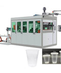 Automatic Disposable Cup Making Machine With PLC Controlled Thermoforming System producing plastic cups in various sizes.