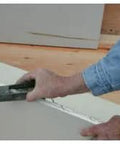 Person using Pocket Drywall And Ceiling Tile Rasp With Replaceable Blade Designed For Fine Edge Trimming Of Drywall And Tiles.