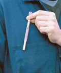 Person holding Pocket Model Grease Joint Rejuvenator Tool By IPA Tools Innovative Products Of America against a blue uniform pocket.