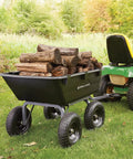 Heavy Duty Poly Yard Dump Cart with 6 Cu Ft Tub 1200 LB Haul Capacity, towable utility wagon loaded with logs, attached to lawn tractor.