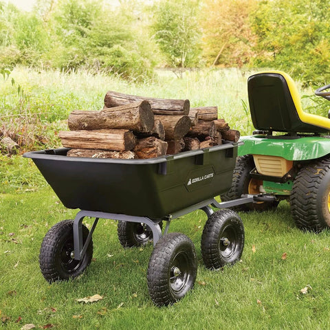 Heavy Duty Poly Yard Dump Cart with 6 Cu Ft Tub 1200 LB Haul Capacity, towable utility wagon loaded with logs, attached to lawn tractor.