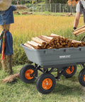 1500 lb Poly Garden Dump Cart Wagon with 2 in 1 Convertible Handle loaded with wood, shown in a field with 13 inch all terrain wheels