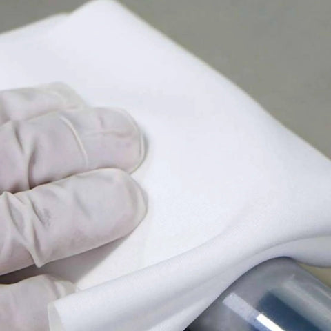 Gloved hand using Ultrasonic Sealed Edge Cleanroom Wiper For Sensitive Surfaces 9 Inch By 9 Inch Polyester Knit on a surface