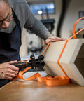 Man using Adjustable Clamp Pony 1225 Rapid Acting Band Clamp with Non Marring 1x1 Inch Jaws on hexagonal wood shape