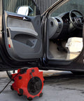 Heavy Duty 1600 Watt Blower Fan With 3 Speeds And 4 Angle Adjustments For Basements Cars And Garages Portable 120V Air Mover With Circuit Breaker And Motor Overload Protection From Stalwart shown blowing air into a car