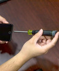 Hands using All-In-One 27-In-1 Precision Screwdriver Set For Apple Device Repairs With Rare-Earth Magnet Barrel by Klein Tools on iPhone.