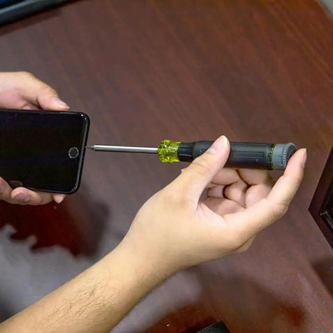 Hands using All-In-One 27-In-1 Precision Screwdriver Set For Apple Device Repairs With Rare-Earth Magnet Barrel by Klein Tools on iPhone.