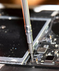 Close-up of All In One Precision Screwdriver Set With 39 Bits For Apple Devices Magnetic Dual End Barrel For One Handed Fastener Retention Case Included Klein Tools Pro Repair Kit For Tech Enthusiasts working on electronic device.