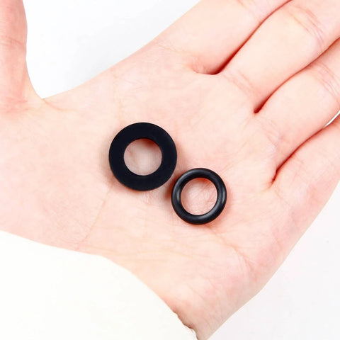 Hand holding gasket and O-ring from Propane Tank Gasket And O Ring Seal Kit With 15 O Rings And 15 Gaskets Plus PTFE Thread Sealing Tape