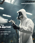 GRITSMITH Natural Walnut Shell Media – front view; worker in white PPE with respirator holding a spray gun
