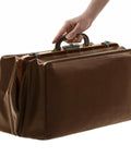 Hand holding a suitcase with a PU Leather Luggage Handle Replacement Strap For Travel Bags Guitar And Musical Boxes Gift Boxes Vintage U Shape