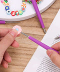 Purple Diamond Tipped Bead Reamer Set Of Four For Jewelry Making Hole Enlarger Tools With Durable Plastic Handles Includes Three Sizes For Enlarging Holes In Plastic Glass And Metal Beads For Easy Beadwork being used to enlarge a flower-shaped bead. 
