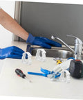 Person using 35 Piece Pipe Clamp Buckle Repair Kit For Water Pipes And Hoses, Heavy Duty PVC Clamp Set near a kitchen sink.