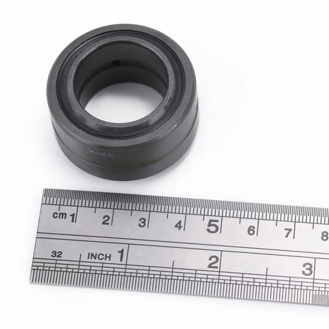 Close-up of double sealed radial spherical bearing with 1.5 inch bore, shown with ruler for scale, made from chrome steel for heavy duty machinery.