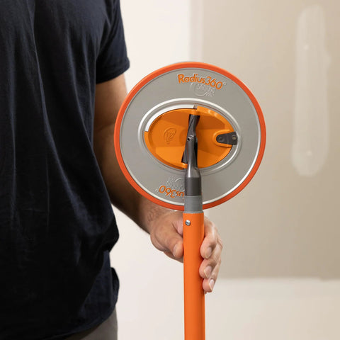 Person holding Radius360 Round Sanding Tool With Interchangeable Center Hub 9 Inch, showcasing handle and pad close-up.
