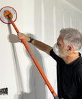 Man using Radius360 Round Sanding Tool With Interchangeable Center Hub 9 Inch on a wall
